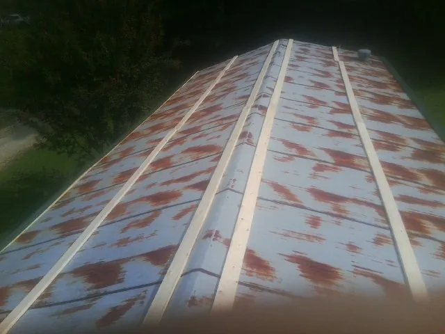Rusted metal roof panels with new wood purlins before replacement — Storm Damage Roof Repair in Heathsville by Roofing Brothers
